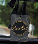 Automašīnas aromatizators ar vārdu grafīta un zelta krāsās, kas karājas automašīnā